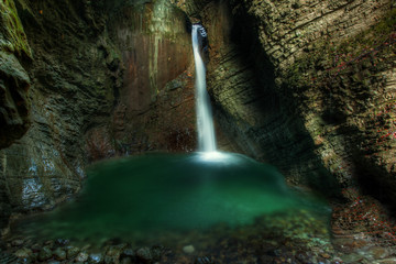 Beautiful waterfall on Kozjak creek in cave in Slovenian Alps in