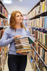 happy student girl or woman with books in library
