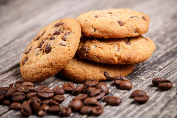 Cookies and coffee beans on a wooden table.