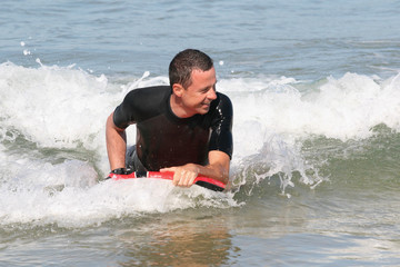 Body boarder riding a wave in the sea for fun
