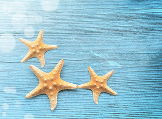 Three starfish on a blue wooden background