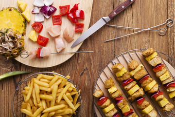 Grilled chicken skewers with pineapple, peppers and onions serve