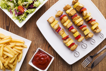 Grilled chicken skewers with pineapple, peppers and onions serve