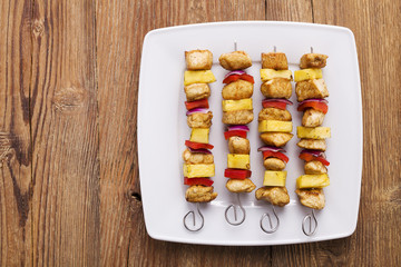 Grilled chicken skewers with pineapple, peppers and onions