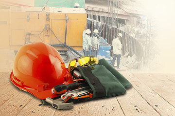safety helmet and tools on wood table and building construction
