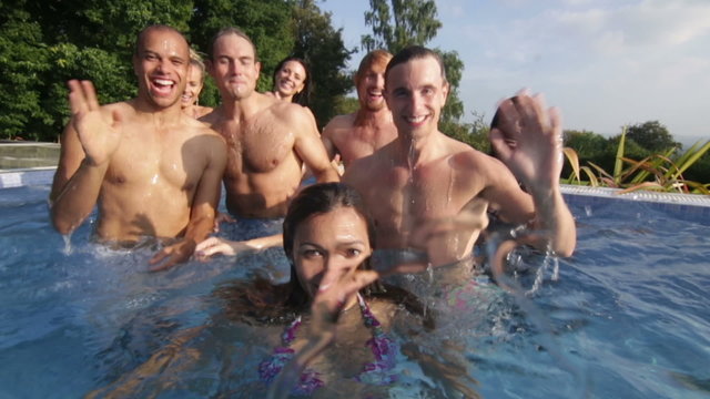 Portrait of happy fun loving friends underwater and above at summer pool party
