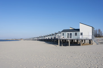 row of luxury tropical beach houses on white sand