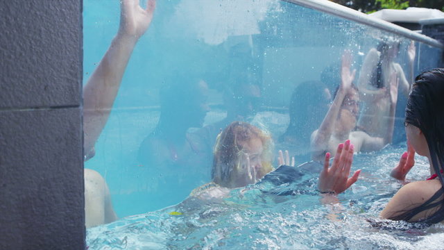 Attractive group of friends enjoy pool party and relaxing in hot tub