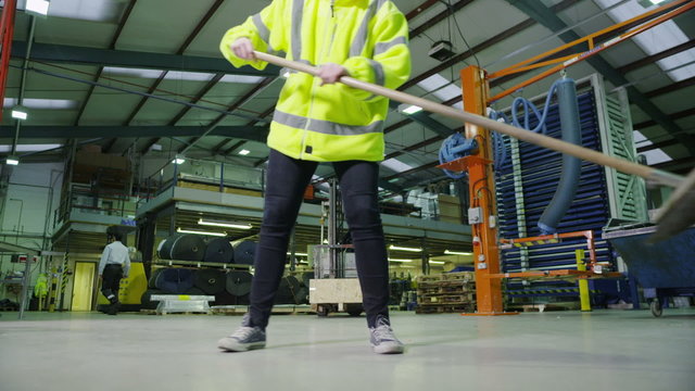 Team of busy warehouse workers lifting and moving empty wooden pallets