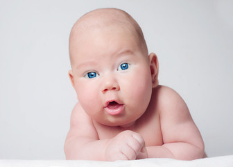 Surprised blue-eyed baby boy looking to camera