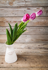 Vase of natural tulips. flowers on a wooden background