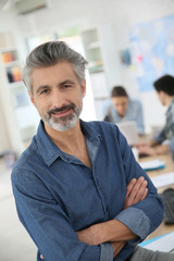 Portrait of mature teacher sitting in class