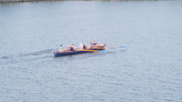 Rowing crew traveling down the River Thames on a sunny day