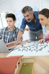 Teacher with students in architecture school