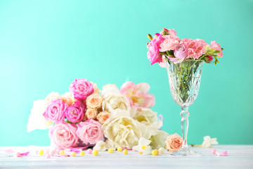Beautiful spring flowers in glass vase on light blue background
