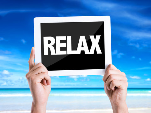 Tablet pc with text Relax with beach background