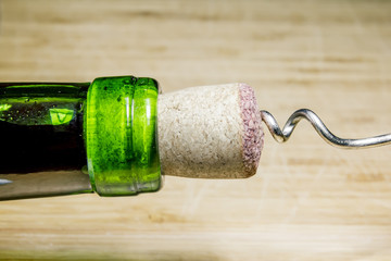 Corkscrew and Cork from wine on a wooden surface