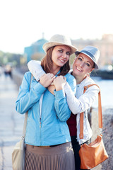 Fototapeta na wymiar Two beautiful girls laughing and hug in the city