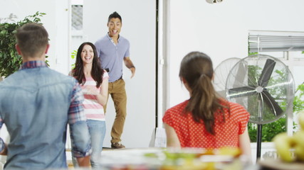 Friendly couple hosting a party at home greet their guests as they arrive. 