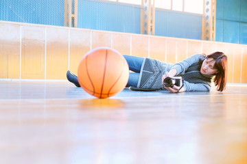 Woman photographs a basketball ball
