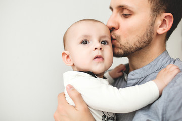 Happy father kissing baby in hands with isolated background