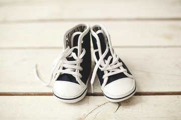 Baby black and white sneakers on wooden floor