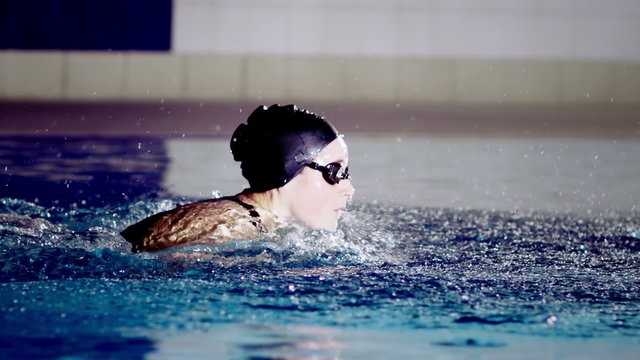 Powerful female swimmer in training doing the butterfly stroke 