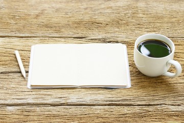 Black coffee and notebook on wooden table