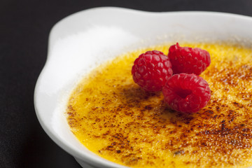 Closeup von einer Crème Brule mit Himbeeren