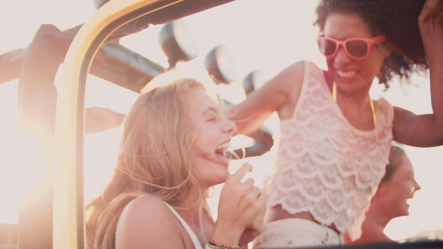 Afro girl laughing with friends on a road trip
