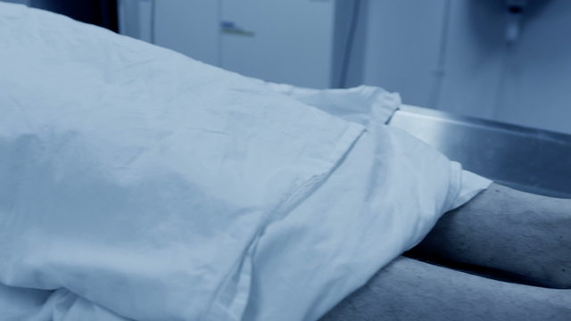 Smoking kills! Dead male body laid out on autopsy table with cigarette in mouth