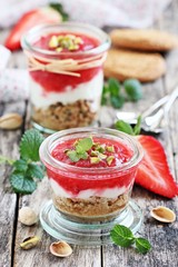 Dessert of oat cookies , yogurt, strawberries and pistachios
