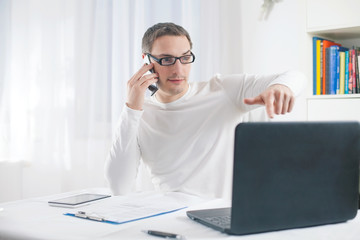 Young businessman working at home using laptop