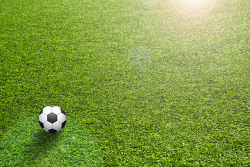 Artificial grass with sun flare and soccer ball