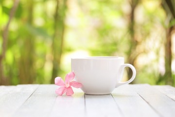 Fototapeta na wymiar White coffee cup and frangipani flower