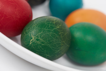 Easter colorful painted eggs on a white plate