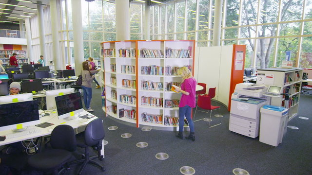 Diverse student group working in the library of large modern university building