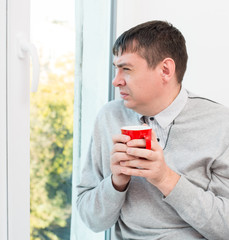 young man holding a cup in his hands