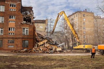 Fototapeta na wymiar excavator demolishes old school building