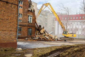 Fototapeta premium excavator demolishes old school building