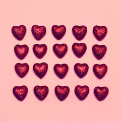 Sweet many red decorative hearts on a pink background