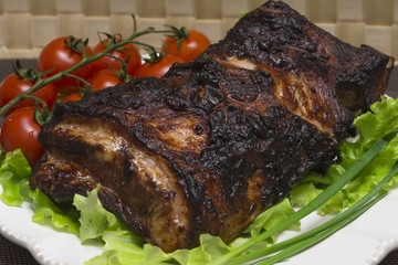 Pork ribs on the salad leaves with cherry tomatoes