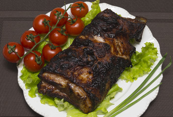 Pork ribs on the salad leaves with cherry tomatoes