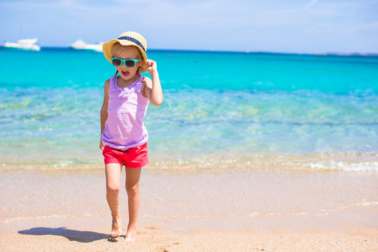 Adorable little girl have fun at tropical beach during vacation
