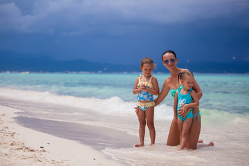 Fototapeta premium Happy mother and two her kids at exotic beach on sunny day