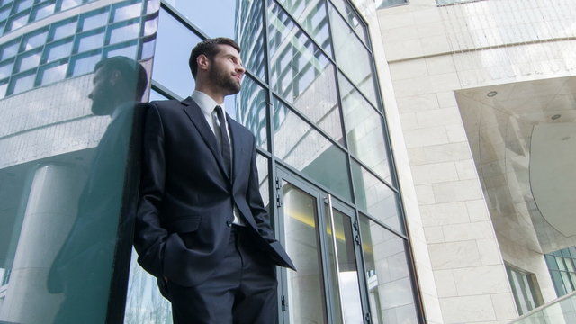Low angle view of businessman standing by the skyscraper