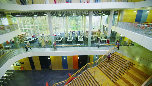 Diverse student group walking through a large modern university building.