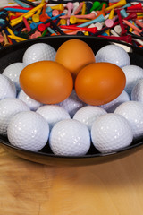 Golf balls and eggs on a black plate