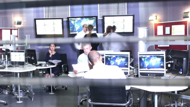 Time lapse security team watching the screens in busy control center office