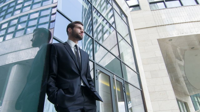 Low angle view of businessman standing by the skyscraper